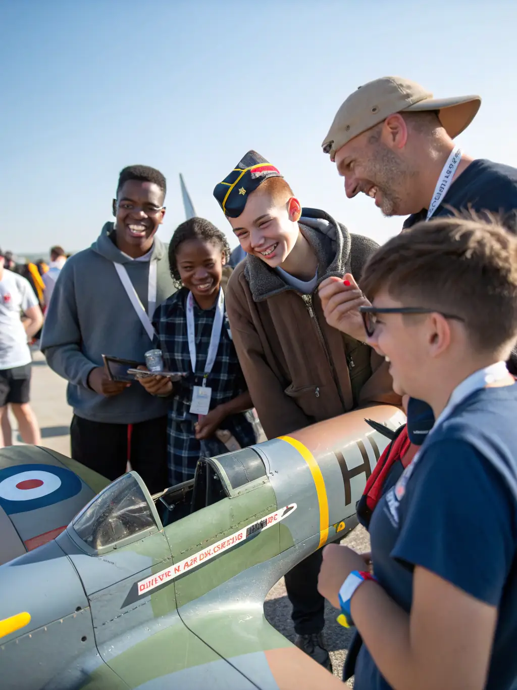 A photograph of a group of AERO CLUB EGLETONNAIS members gathered at the airfield, smiling and engaged in a pre-flight briefing. The image conveys a sense of community, camaraderie, and shared passion for aviation within the club.